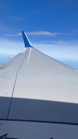 Airplane flying high above the beautiful blue sky with white fluffy clouds	