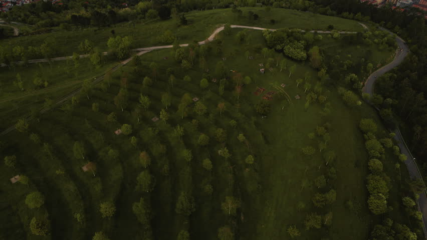 Drone flying forward over green hills revealing Bilbao city skyline, buildings and urban landscape. Scenic aerial view of Basque Country in northern Spain. High quality 4k footage