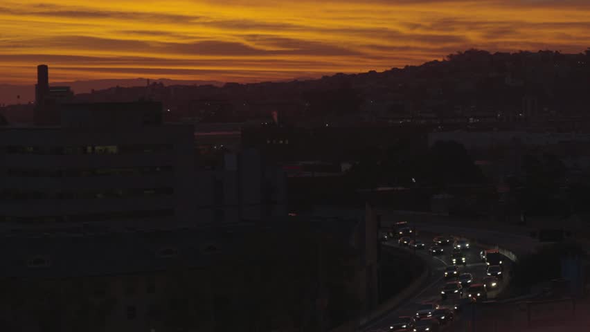 Wide sunset shot of San Francisco with road traffic below right, Twin Peaks