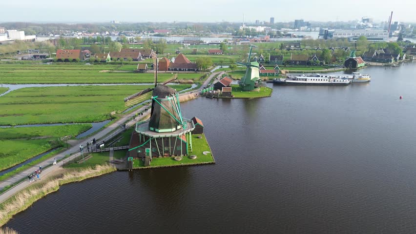 traditional Dutch windmills of Zaanse Schans over water at summer sunset, Netherlands