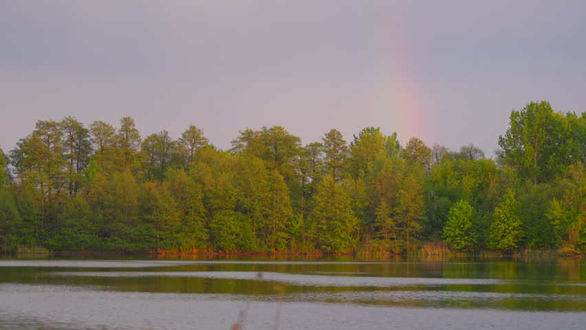 autumn landscape with a rainbow over the lake