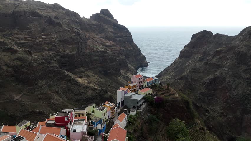 Aerial view of Fontainhas village perched on cliffs in Santo Antao, Cape Verde. Iconic colorful houses in a deep volcanic valley opening to the Atlantic Ocean under a dramatic sky