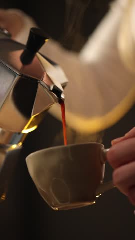 Fresh coffee is poured from a moka pot into a cup in a home kitchen. The video captures a quiet morning routine and the process of brewing a traditional stovetop coffee.