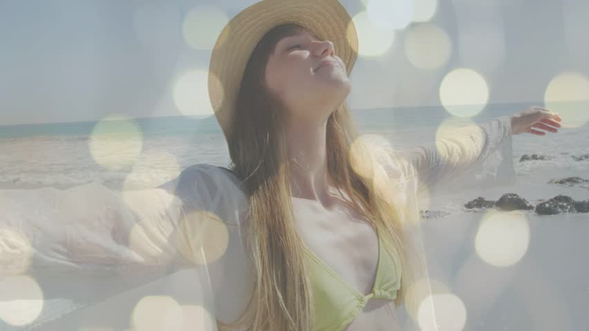 Woman on beach stretching upward while sunlight inspiring bokeh bathing her, seeking wellness. Female, stretch, seaside, waves, coast, dreamy, serenity