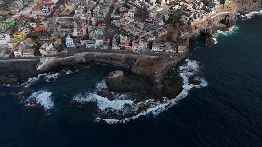 aerial perspective of the coastal town Ponta do Sol in Santo Antao, Cabo Verde. Colorful buildings perched on volcanic cliffs overlooking the deep blue Atlantic ocean