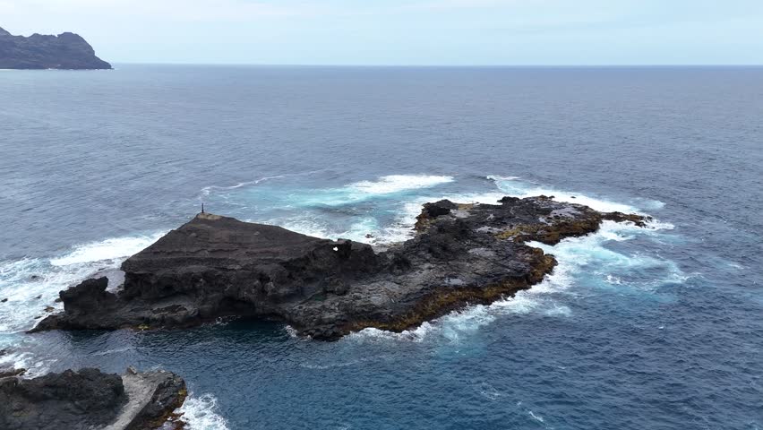Stunning aerial view of a volcanic rock promontory jutting into the turquoise Atlantic waters near Cruzinha, Santo Antao, Cabo Verde. Pure coastal wilderness and dramatic island geology