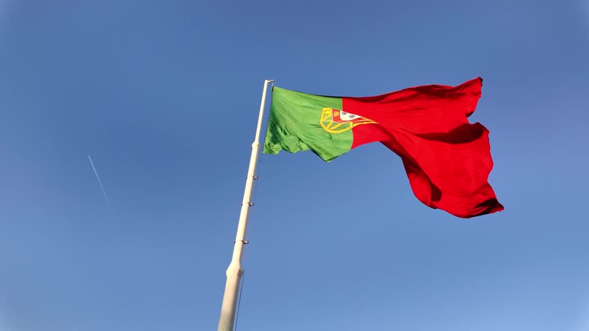 Portugal National Flag Billowing in Wind Over Bright Blue Sky