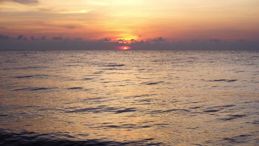 Vivid Orange and Red Sunset Over Open Sea with Glowing Sky and Golden Light Reflected on Water