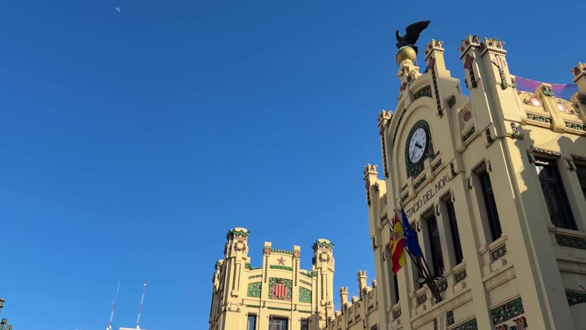 Estació del Nord showcasing detailed Art Nouveau architecture and the prominent clock tower with a prominent eagle sculpture, a historic railway station in Valencia, Spain