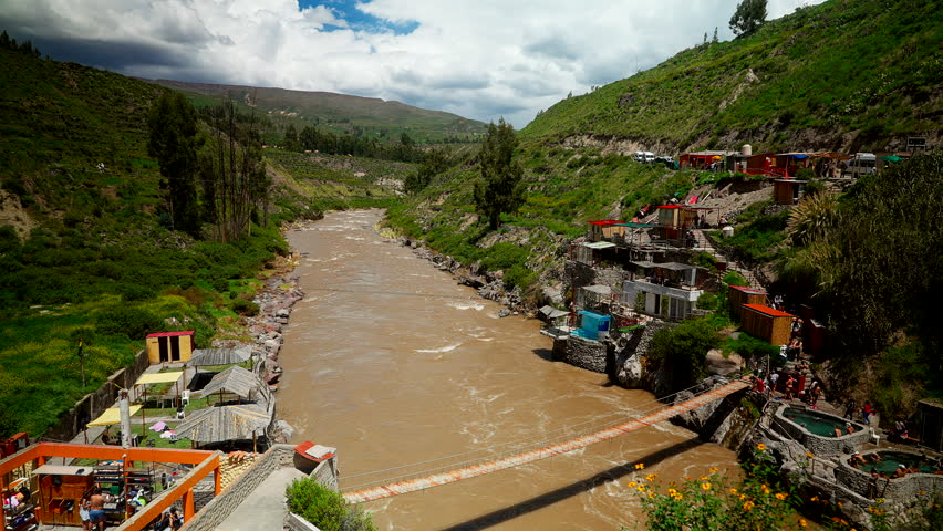 Scenic view of the muddy river flowing under a bridge at Banos Termales de Chacapi near Chivay in the Colca Canyon region of Peru, South America