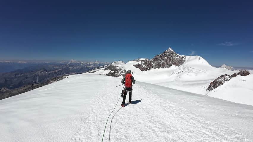 POV mountaineering in rope team with mountaineer and mountain glacier panorama with summit Lyskamm in summer in Pennine Alps, Italy