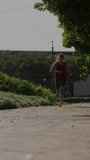 Female runner approaching camera on park path, initiating nodes or lines displaying fitness metrics. Outdoors, athlete, smartwatch, motion, overlay, network, vertical video - Powered by Shutterstock - Get 15% off with code: PIKWIZARD15
