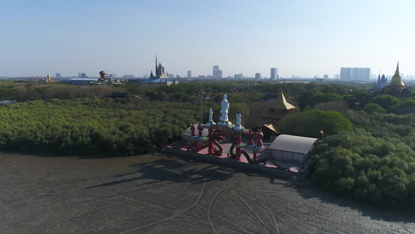A wide panoramic perspective of the Sanggar Agung Temple complex, highlighting its vibrant red structures, traditional Chinese motifs, and its tranquil location at the edge of the Madura Strait