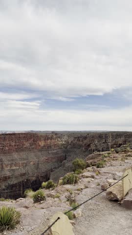 Scenic panoramic view of the Grand Canyon West Rim in Arizona, USA. Desert landscape with layered red rock cliffs, deep canyon formations, Colorado River view. A road trip near Eagle and Guano Point