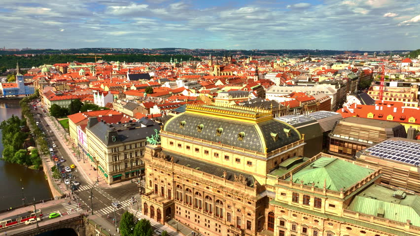 Theatre in Prague city. Opera heritage across water. Theatre historic Prague city center. Theatre stands iconic in Prague near Vltava River. Praha city theatre. Prague opera aerial view.