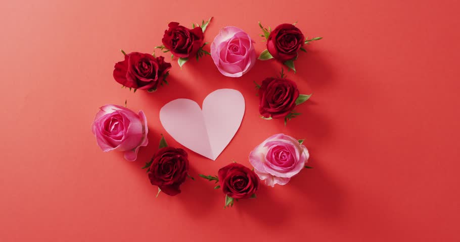 Red and pink roses with heart on red background at valentine