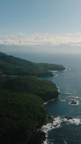 Tropical landscape with ocean waves on coastline. Surigao del Sur, Mindanao, Philippines. Vertical view.