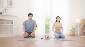 Asian couple practicing yoga class exercise together in living room at home, healthy wellness lifestyle fitness routine, stretching and balance poses, indoor workout for flexibility strength relaxation and mindfulness training - Powered by Shutterstock - Get 15% off with code: PIKWIZARD15