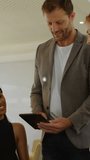Vertical video: Woman tapping tablet, man supporting, AR web growing into data nodes for biz review. Collaboration, teamwork, professionals, device, augmented, reality, vertical video - Powered by Shutterstock - Get 15% off with code: PIKWIZARD15