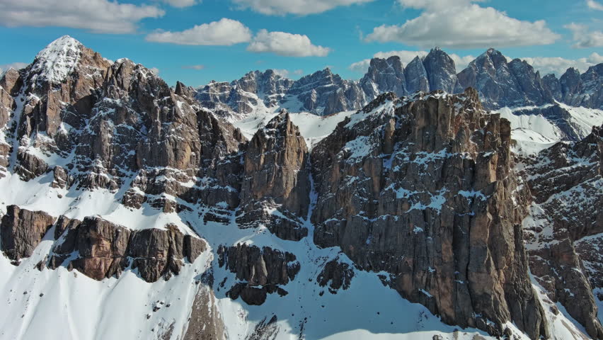 Aerial view of majestic rocky mountains in snow Alps, Dolomites, Italy, 4k