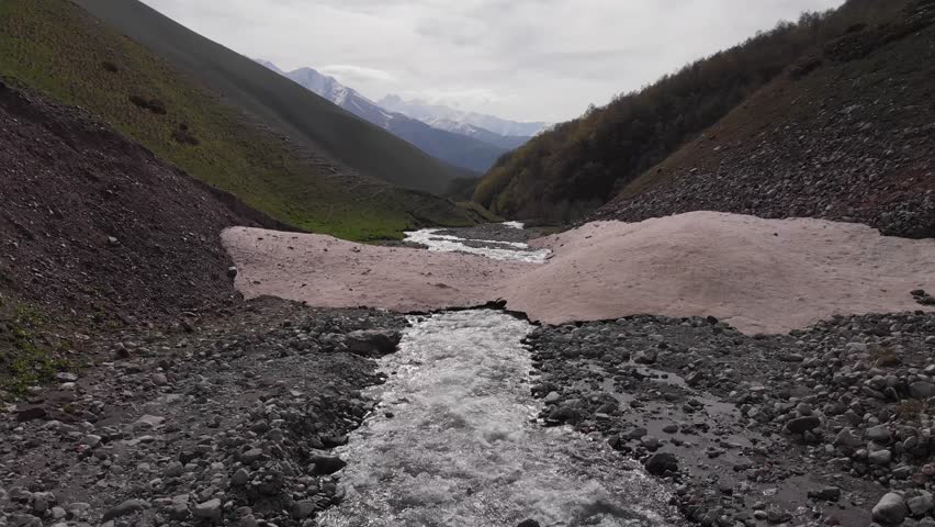 Caucasus, North Ossetia. Adaykom Gorge. Snow bridge over the river.