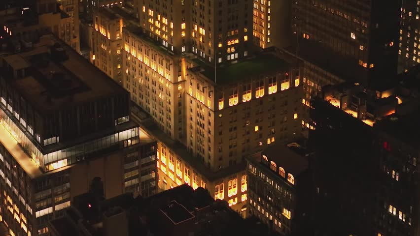 A comprehensive aerial panorama of the illuminated skyscrapers of New York City, capturing the scale and energy of the metropolis.