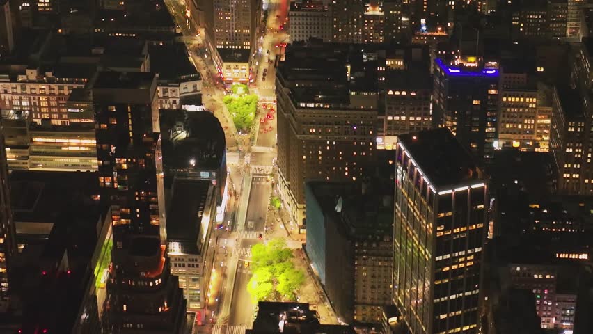 A vast aerial panorama of Midtown Manhattan skyscrapers at night, with thousands of illuminated windows stretching towards the horizon.