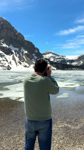Man photographing frozen Bow lake in Banff National Park