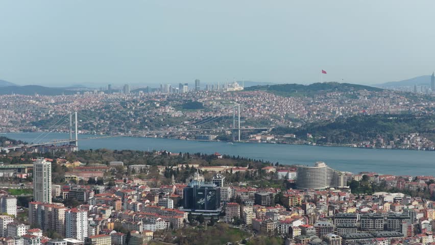 Expansive aerial panorama showing bustling metropolis of Istanbul, Turkey, with iconic Bosphorus Bridge spanning strait between Europe and Asia