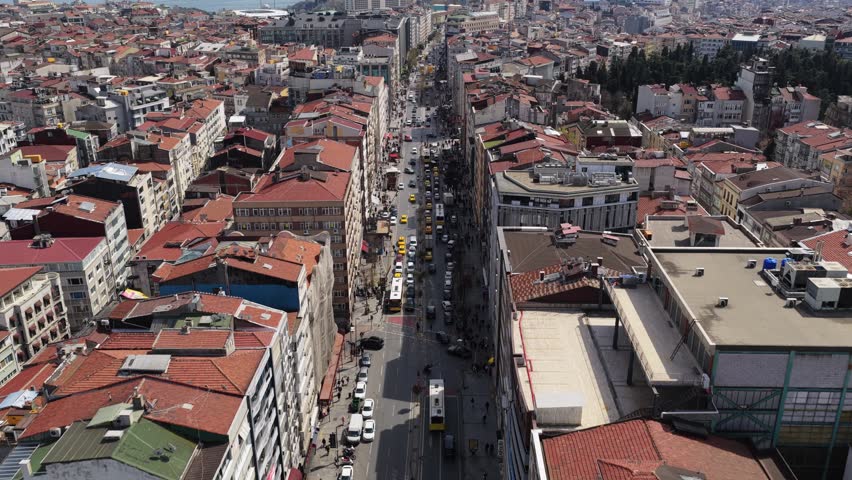 Urban landscape of Istanbul showcasing bustling Istiklal Avenue with dense city traffic, historic architecture, expansive metropolis reaching Bosphorus Strait