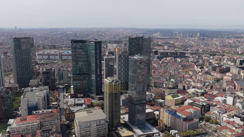 Flying above Istanbul metropolis showing modern skyscrapers in business district contrasting with traditional low rise buildings and cityscape of Turkey