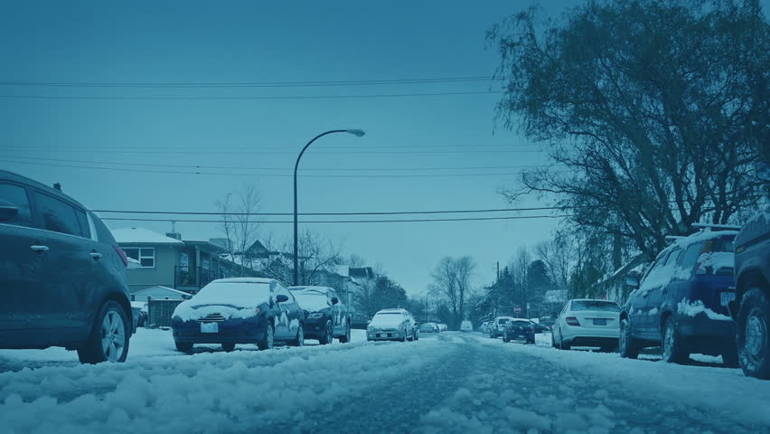 Road In Snowfall With Passing Cars Residential Area