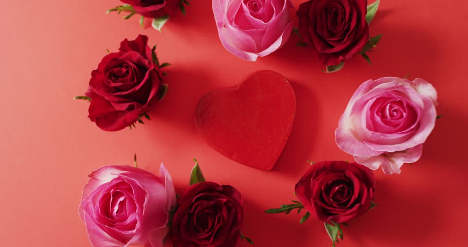 Red and pink roses with heart on red background at valentine