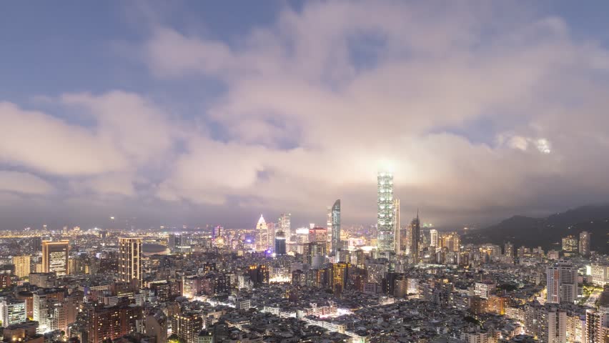 Time Lapse of clouds and the moon moving above the skyline of Taipei Taiwan at night.