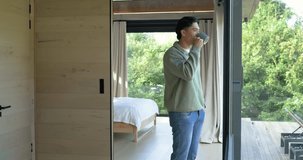 Couple sipping coffee and gazing forest view in cabin with woman entering to share morning moment. Coziness, serenity, intimacy, nature, outdoor, relaxation, rustic - Powered by Shutterstock - Get 15% off with code: PIKWIZARD15