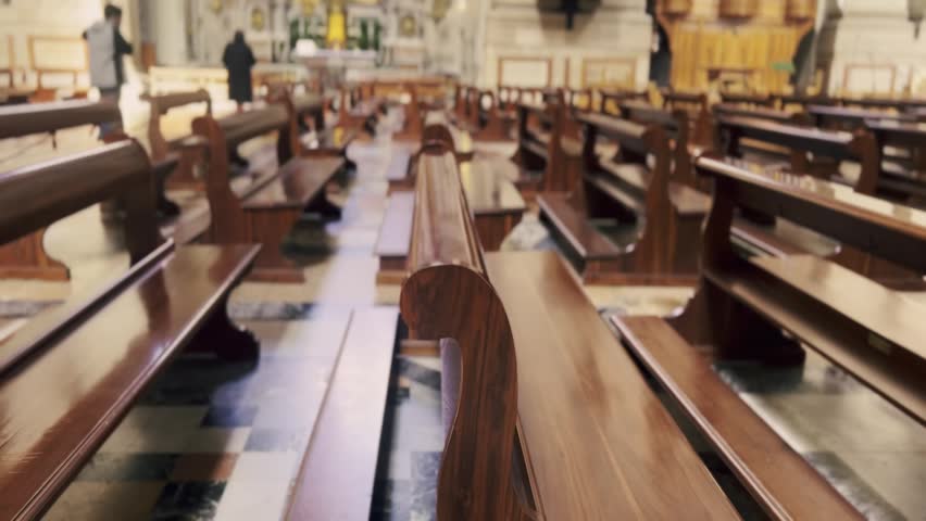 Majestic view of a quiet christian church interior with rows of empty polished wooden pews leading to the altar, a perfect representation of faith, solitude, and religious contemplation