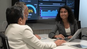 Business team meeting with presenter explaining data analytics dashboard on large screen. Charts, graphs, and performance metrics highlight corporate strategy, teamwork, and modern business intelligence. - Powered by Shutterstock - Get 15% off with code: PIKWIZARD15