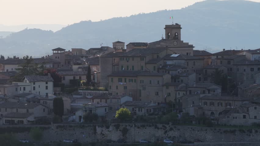 Aerial view of the medieval hilltop village of Montefalco featuring ancient stone buildings and a bell tower against rolling hills Montefalco, Umbria, Italy.