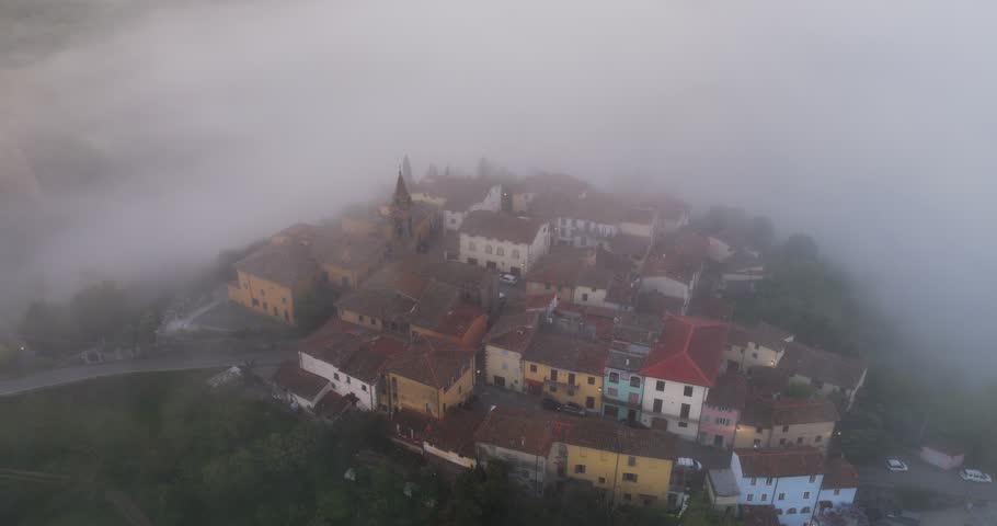 Aerial view of the historic village of Piantravigne shrouded in thick morning fog and mist over the Tuscan hills Piantravigne, Tuscany, Italy.