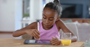 Female child of African descent responding to tablet, leaning and drawing with white stylus at home. Preteen, girl, learning, edtech, table, cozy, natural - Powered by Shutterstock - Get 15% off with code: PIKWIZARD15