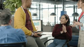 Coworkers at desk tapping tablet, revealing animated graphs over group for business analytics. Collaboration, office, dashboards, data, teamwork, daylight, greenery - Powered by Shutterstock - Get 15% off with code: PIKWIZARD15