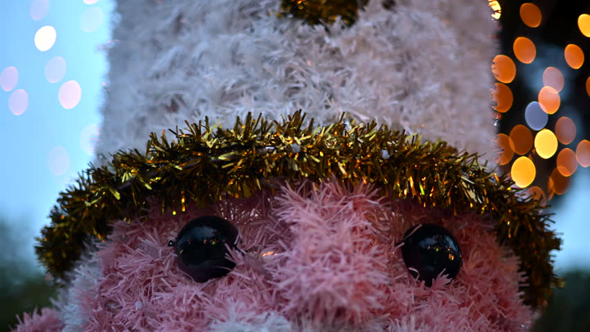 Close up of a decorative Christmas nutcracker soldier figure displayed outdoors with trees in the background