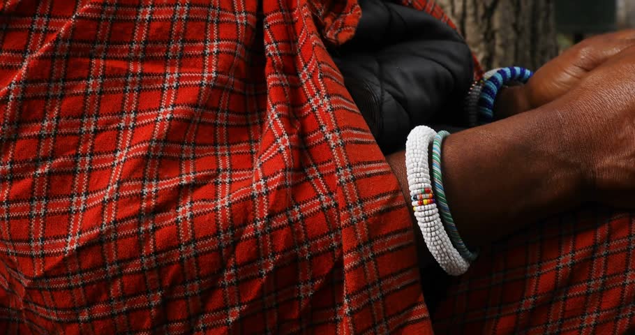 Vertical video: Mature man tapping smartphone on lap with globe fading in, causing tech overlay. Urban, bench, plaid, beads, device, candid, park