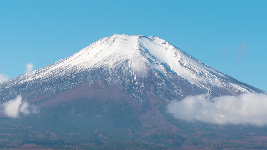 4K Time lapse of Clouds with Mt. Fuji over Lake Yamanaka, Japan. Timelapse of Mount Fuji with clouds on Blue sky background.