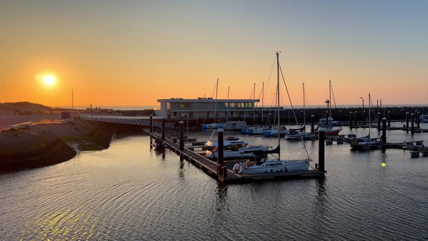 Scenic Marina with Docked Sailboats and Yachts during a Beautiful Golden Sunset over the Sea