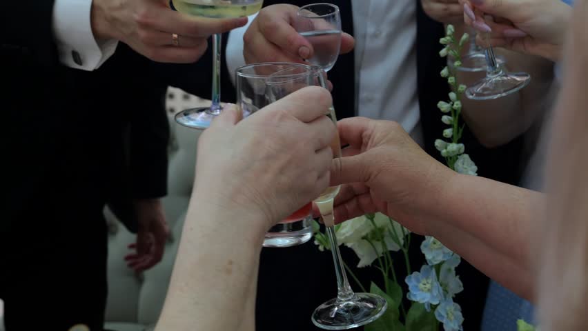 Close-up of a cheerful festive group of people clinking glasses of champagne at a wedding or other special event.