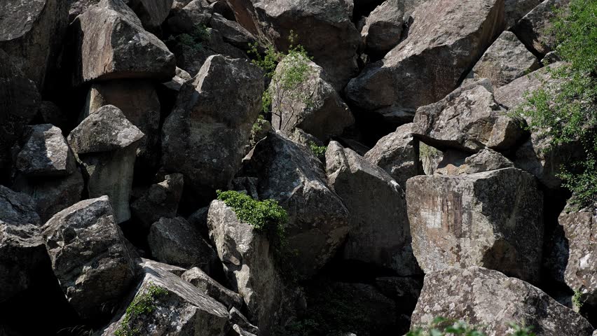 Close-up of a large mountain of stones. The rocks are piled up in a big heap. The collapse of the mountain has left a large pile of rocks.