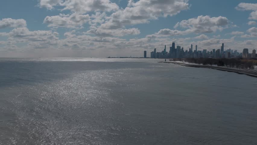 The Chicago skyline on the massive Lake Michigan on a sunny day with giant picturesque clouds.