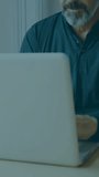 Vertical video: Man typing on laptop, causing green binary overlay and scanline for tech demo. Workstation, professional, senior, coding, homeoffice, office, vertical video - Powered by Shutterstock - Get 15% off with code: PIKWIZARD15