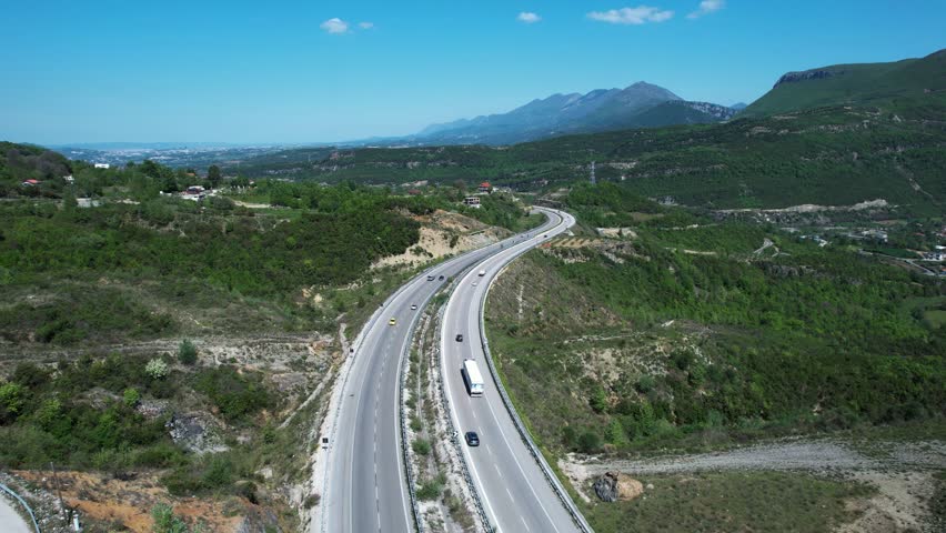 Mountain Highway Passing Through Green Hills Toward the Developing Capital City Skyline of Tirana